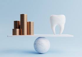 tooth balanced against stacks of coins