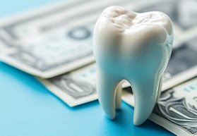 A single tooth next to a pile of money