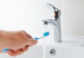 Rinsing off toothbrush under sink