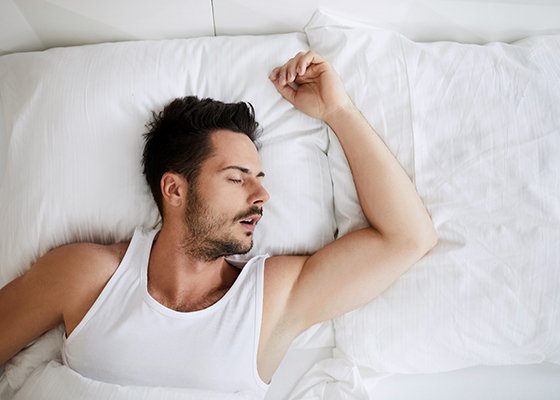 Young man snoring while lying in bed