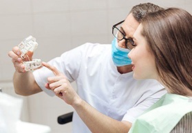 dentist showing a dental implant to a patient 