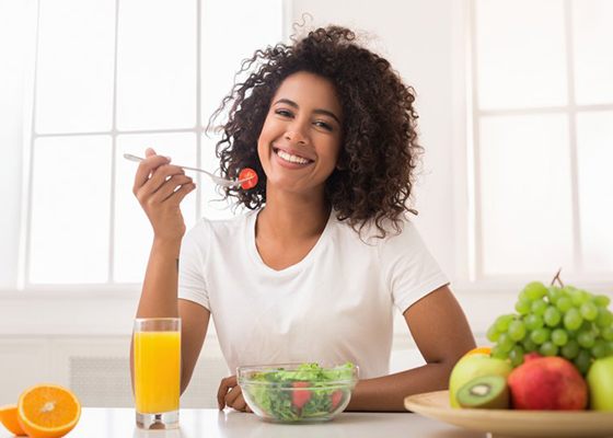smiling woman eating a salad