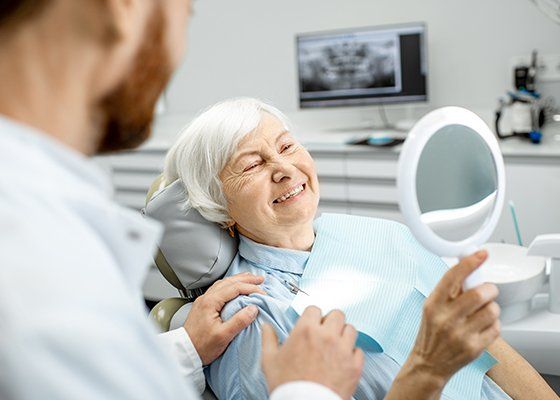 elderly woman smiling into mirror