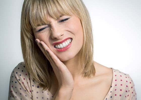 Woman with a toothache in Annapolis touching her face