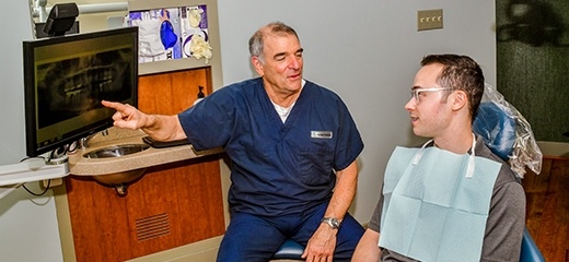 Annapolis dentist pointing to x ray with dental patient