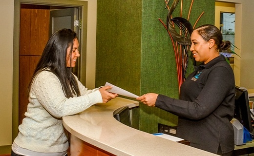 team member handing patient paperwork