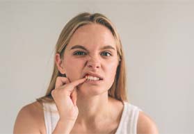 Woman poking at her gaps between teeth in Annapolis