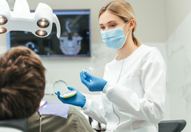 Dentist showing patient clear aligner in treatment room