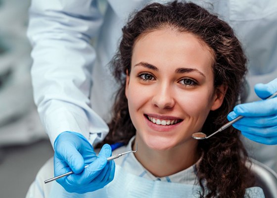 woman with curly hair smiling before undergoing periodontal therapy in Annapolis 