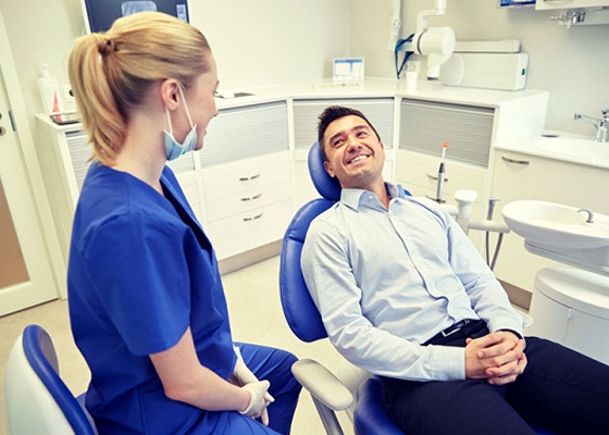man in light blue dress shirt smiling at dentist