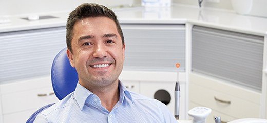 man smiling at camera in exam chair