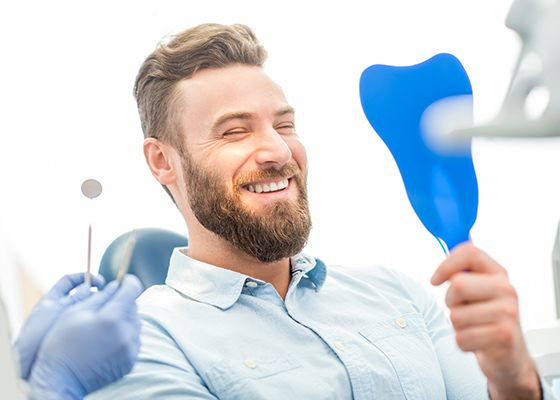 Man admiring his new veneers in Annapolis