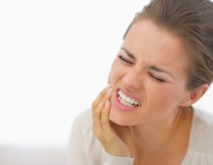 woman holding jaw from tooth pain