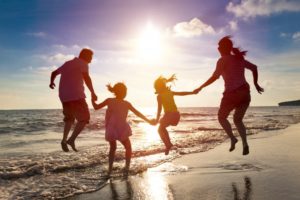 family jumping on beach