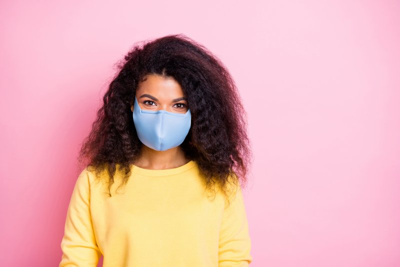 Young woman wearing face mask and a yellow sweater