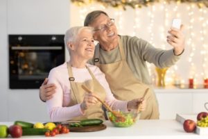 Man and woman in a kitchen smiling and taking a selfie 