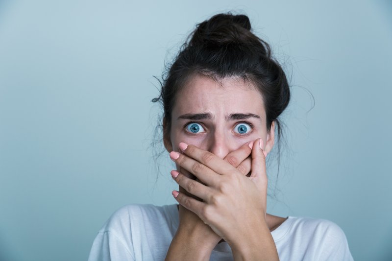 woman in shock with hand over mouth