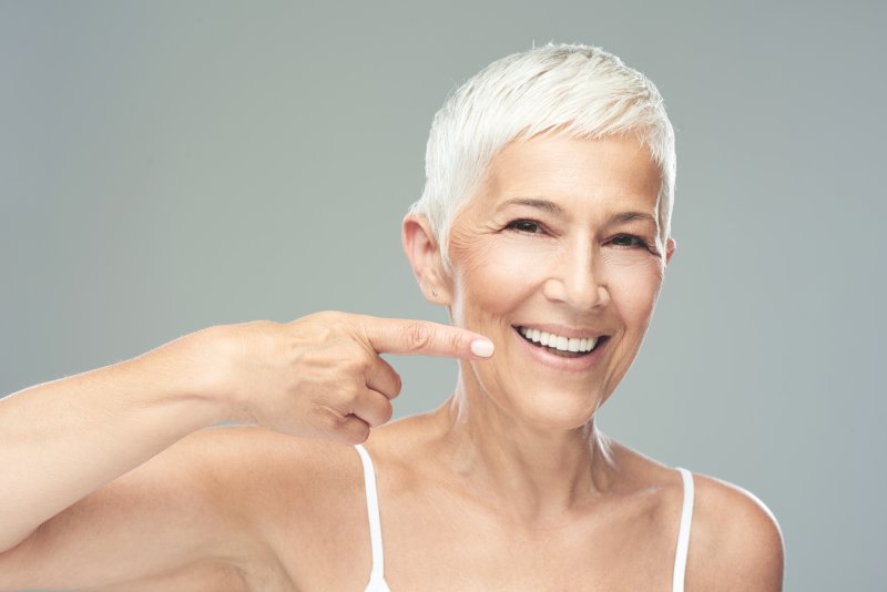 person pointing to their dental implants