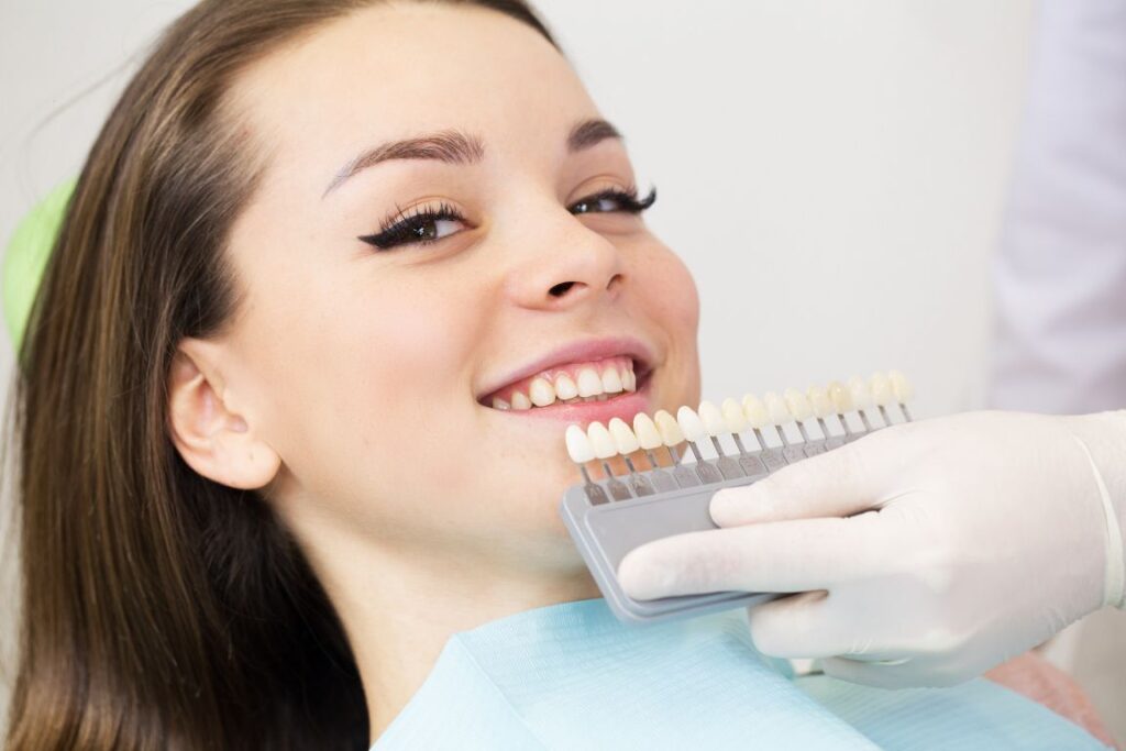 A woman at the dentist using a tooth shade chart