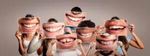 Kids holding blown-up pictures of teeth over their faces.